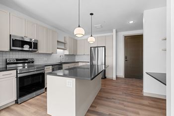 Renovated kitchen with white cabinets and black counter tops